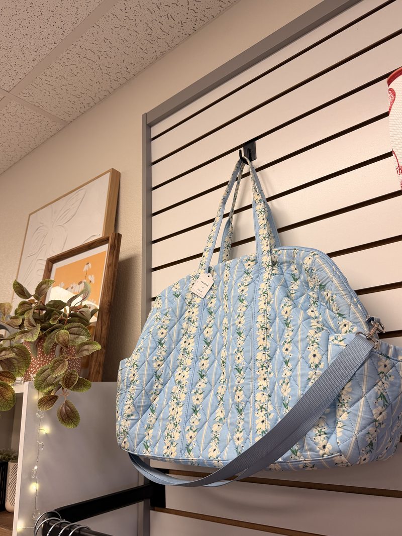 A pale-blue floral quilted weekender bag at Soco Chic Boutique